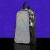 Reflective shimmering silver disco ball pattern skin on a clear anti-theft hydration pack for festivals, shown on a studio purple background