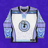Limited edition white and lavender Lunchbox hockey jersey for festival apparel featuring embroidered circular lock logo on front.
