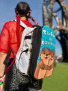 A person at a music festival wearing the Lunchbox Extra Storage Skin 2.0. The black expandable skin is zipped open to reveal a mesh interior pocket holding colorful Kandi bracelets and festival accessories.