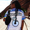 Back view of woman wearing limited edition white and purple Lunchbox festival baseball jersey with music note lock logo at Red Rocks.