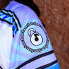 Close-up detail of embroidered circular Lunchbox fam patch with musical padlock icon on sleeve of limited edition baseball jersey.