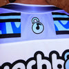 Close-up detail of upper back collar and embroidered musical padlock icon on limited edition Lunchbox festival hockey jersey.