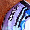 Close-up detail of embroidered Lunchbox logo patch and black stripes on sleeve of limited edition festival hockey jersey.