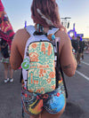 Rear view of a person with pink hair wearing a white Lunchbox hydration pack with a colorful Lollapalooza skin at a festival