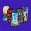 Five colorful interchangeable Lunchbox hydration pack skins with various artistic designs including a desert landscape, a red skull, a trippy astronaut, and a sticker-covered black skin, displayed against a solid purple background.